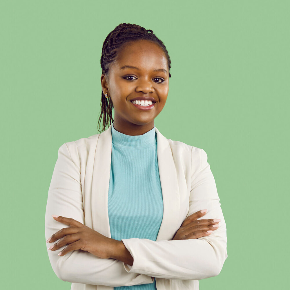 Smiling person standing with their arms folded